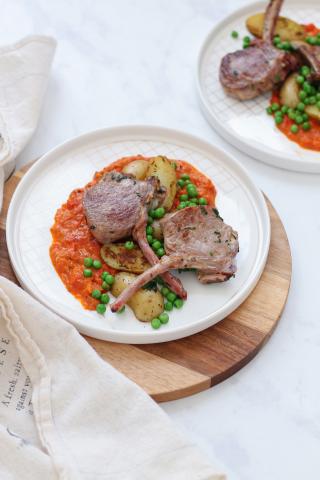 Côtelettes d’agneau, sauce aux poivrons, petits pois et pommes de terre Grenaille